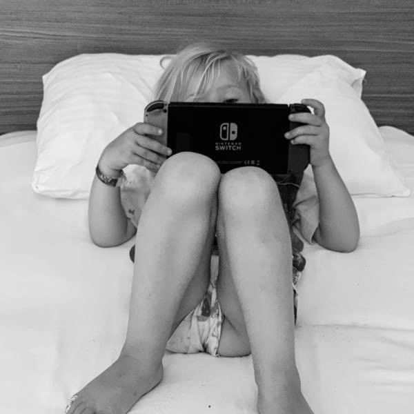 Young girl in bed playing on Nintendo Switch